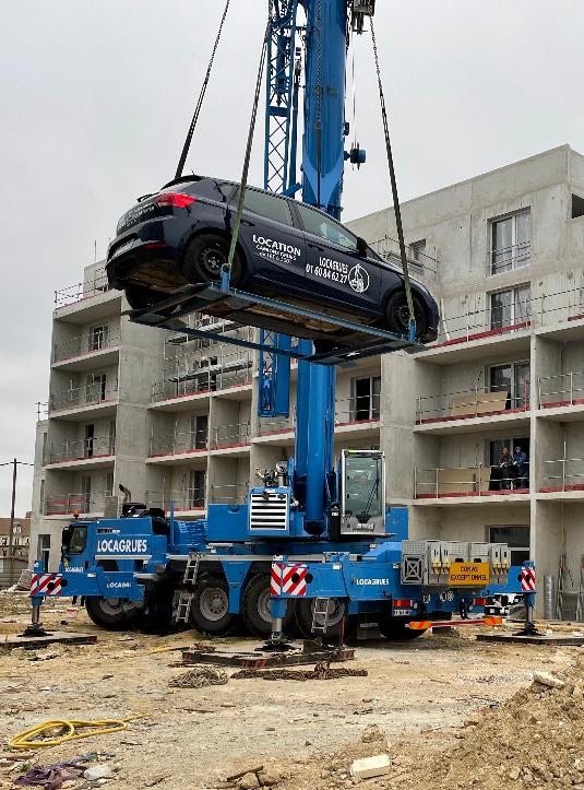 grue à tour qui souleve une voiture 